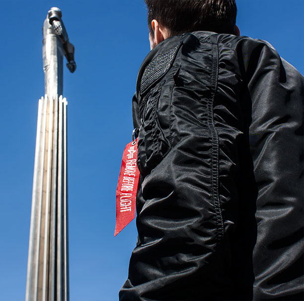 лента Remove Before Flight, черная куртка Alpha Industries, небо, памятник Гагарину