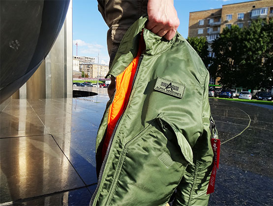 мужская куртка-бомбер в руке, площадь Гагарина, Москва, фирменная нашивка альфа индастриз